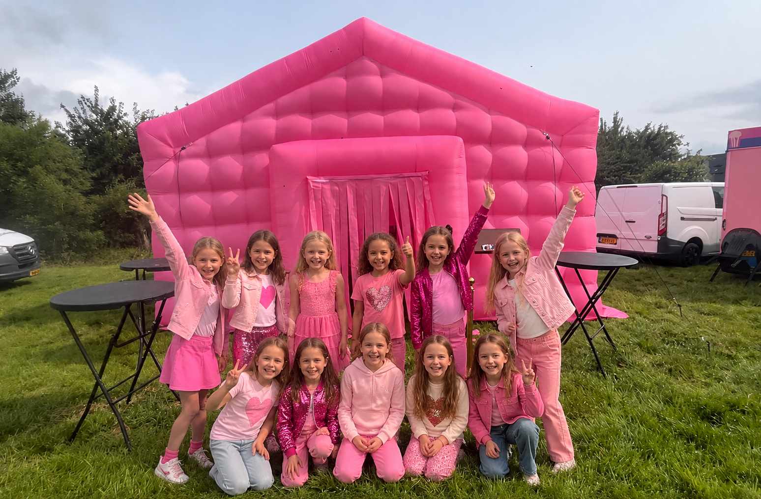 Kinderen bij een roze opblaasbare feesttent
